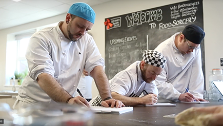 3 chef's scribbling in the kitchen